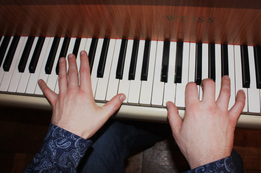 Hände an Klaviertastatur